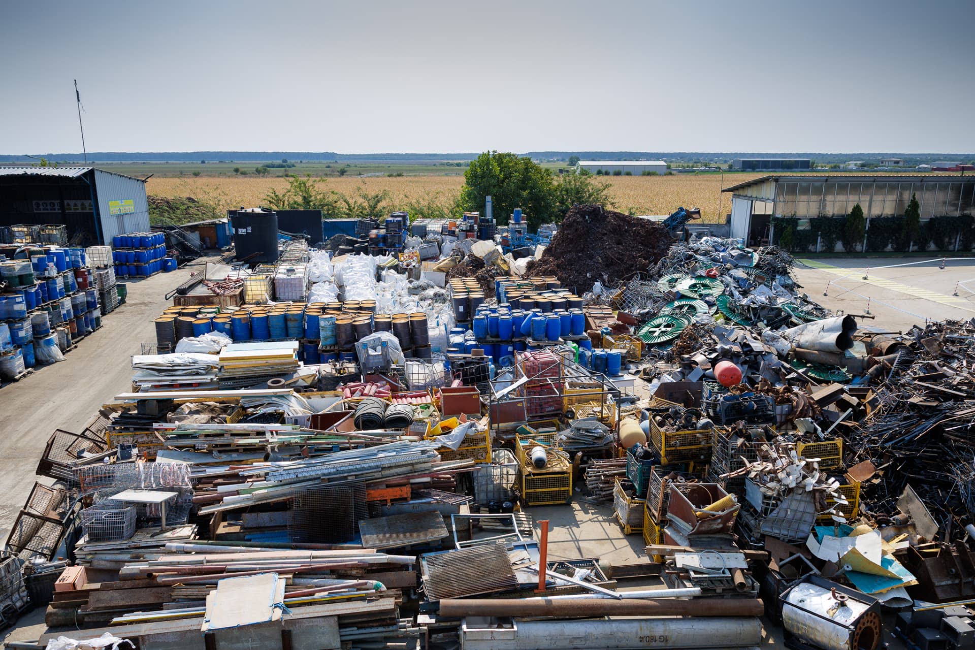 Recovery yard with sorted metals, cable drums and drums of collected waste